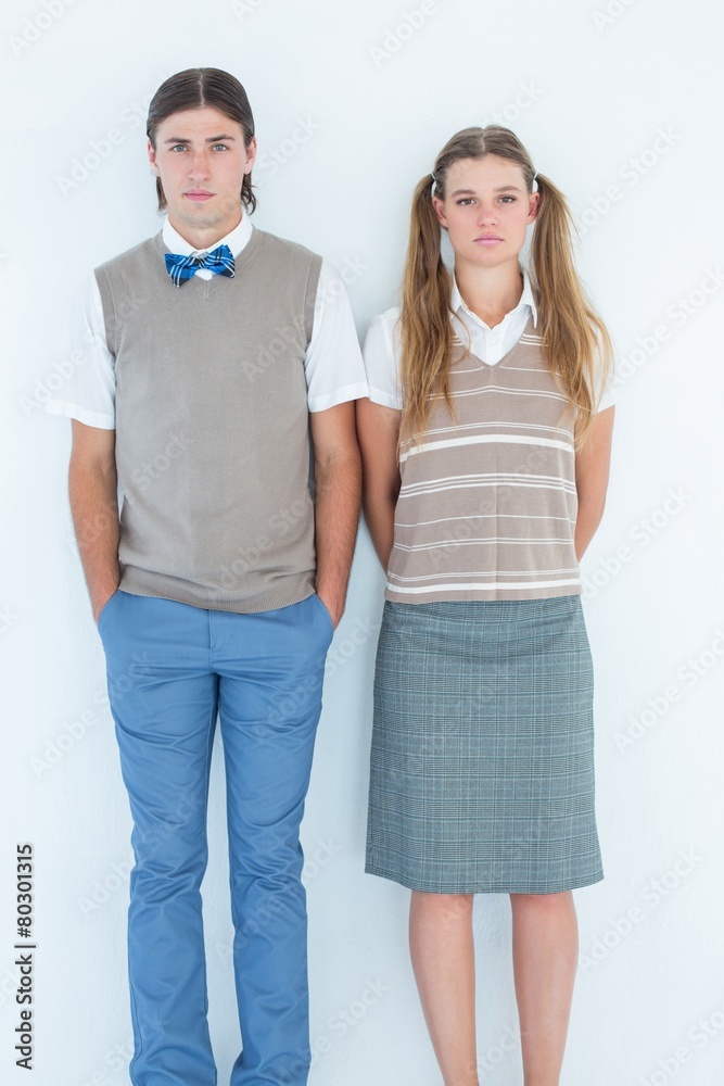 Poster unsmiling geeky hipsters looking at camera