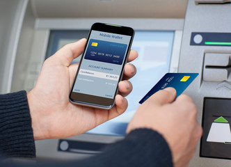 man holding phone with mobile wallet at the ATM
