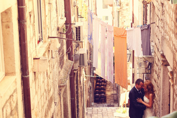 Fototapeta na wymiar groom and bride on a narrow street