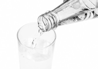 Drinking water is poured from a bottle into a glass