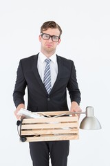 Sad geeky businessman holding box of his things