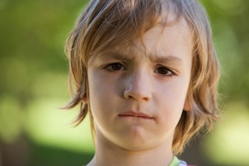 Sad little boy in the park