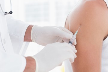 Doctor doing an injection to his patient