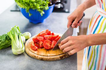 Gorgeous woman mixing a salad in her kitchen