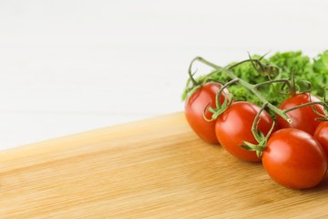 Cherry tomatoes and parsley on chopping board