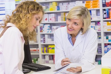 Obraz na płótnie Canvas Pharmacist showing prescription to a customer