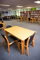 Empty seats and bookshelves at college library