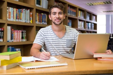 Student studying in the library with laptop