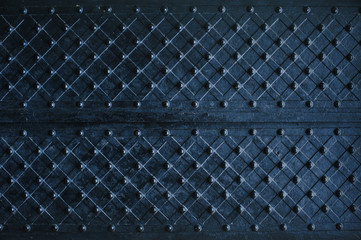Texture of dark wooden gate with metal strips chipped