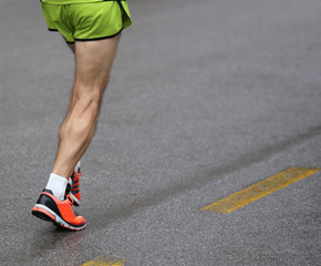 Legs of athlete during the road race and the yellow line
