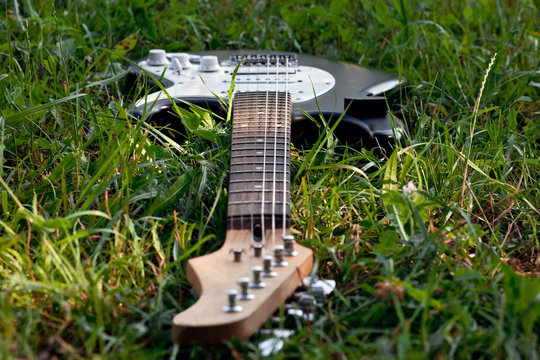 Guitar dropped in wild grass, focus in the middle