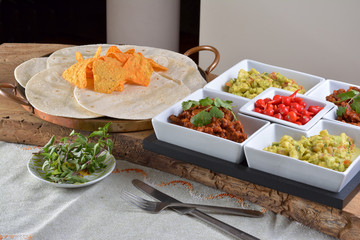 Mexican food - chilli, guacamole, tortillas and nachos