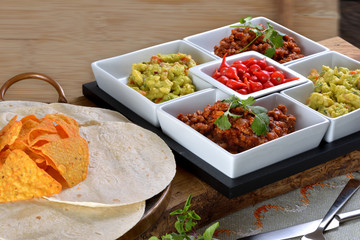 Mexican food - chilli, guacamole, tortillas and nachos