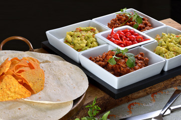Mexican food - chilli, guacamole, tortillas and nachos