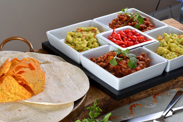 Mexican food - chilli, guacamole, tortillas and nachos