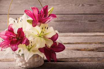 lily in basket on wooden background