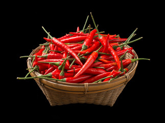Red chillies in a basket isolated on black background