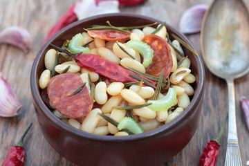 Beans and chorizo cooked with vegetables and rosemary leaves.