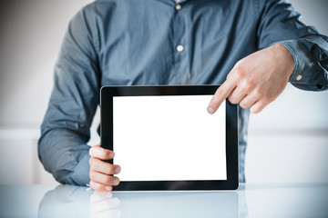 Businessman pointing to a blank screen of a tablet