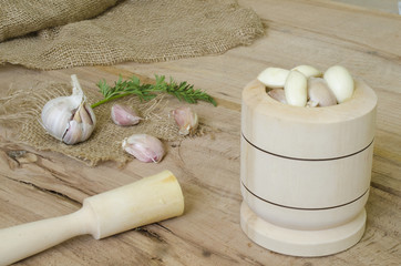 Garlic and parsley leaves on wood and canvas