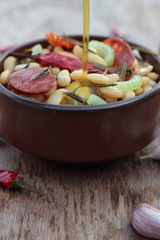 Beans and chorizo cooked with vegetables and rosemary leaves.