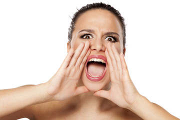 young woman shouting at you with hands beside her mouth