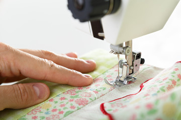 Working on sewing machine. Close look of hands and needle