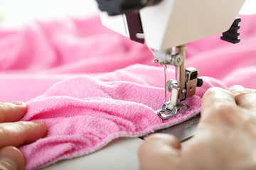 Working on sewing machine. Close look of hands and needle