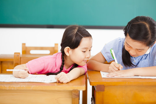 Little Girl Student Trying To Cheat At Test In Class