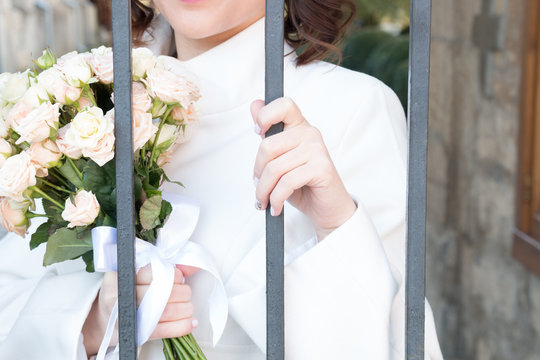 bride with flowers behind bars