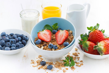 healthy breakfast - granola, fresh berries and milk, close-up