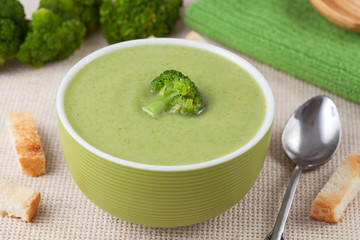 Portion of vegan green broccoli cream soup with croutons and