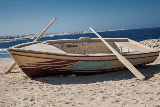 Wooden boat with two oars on beach