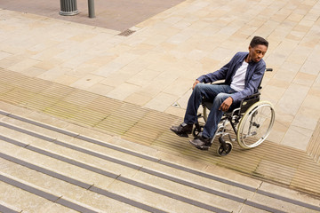 young man in a wheelchair at the bottom of a staircase