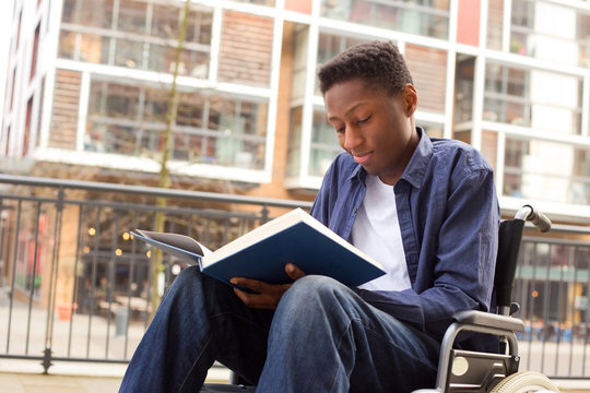 a young wheelchair user reading a book.