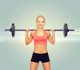 smiling sporty woman exercising with barbell