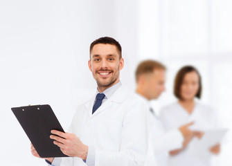 smiling male doctor with clipboard