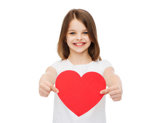 smiling little girl giving red heart