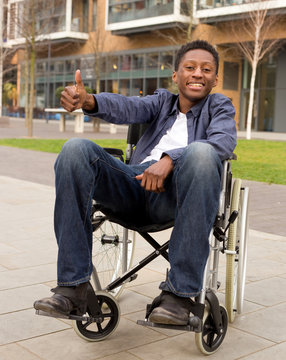 young wheelchair user showing the thumbs up symbol