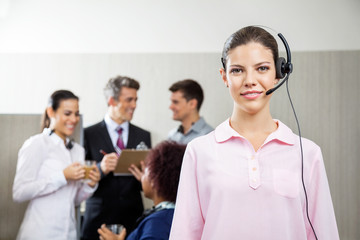 Confident Female Customer Service Representative Standing At Off