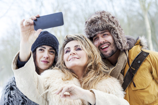group of person taking selfie in winter forest