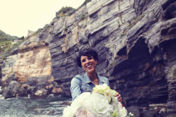 bride with wedding bouquet near the water