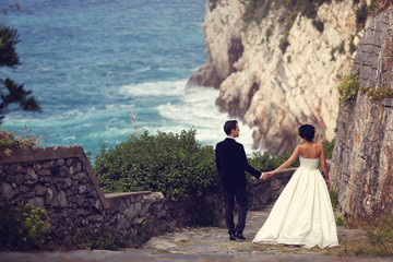 groom and bride outdoors on their wedding day near the sea