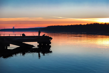 The fishermen on the pier by the river