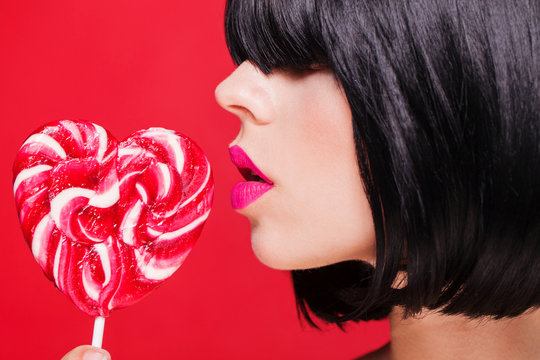 Closeup photo of a beautiful sexy pink lips with lollipop
