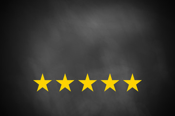 five golden stars on black chalkboard