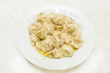 cooked pelmeni sprinkle with pepper
