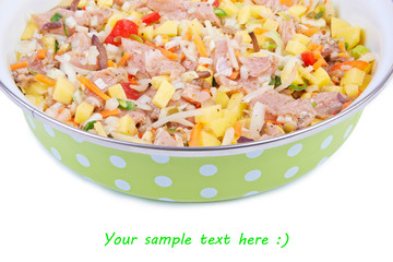 Raw meat with vegetables in a pan isolated on white background