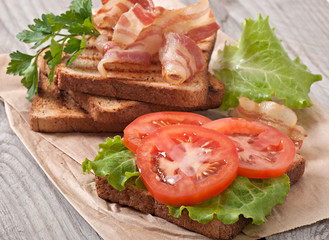hot big sandwich, toast and bacon with tomato, parsley, lettuce
