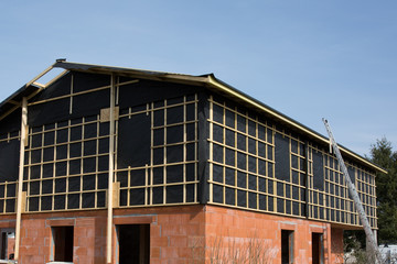 Construction site with the house in scaffolding with blue sky